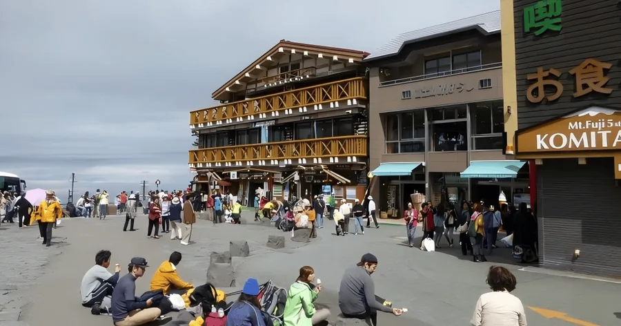 富士スバルライン五合目：木造の建物と売店が並び、広場には観光客と登山者
